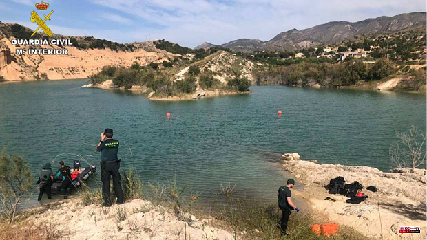 Civil Guard divers look for a missing young man swimming across the Crevillente reservoir