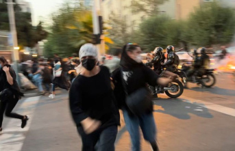 Tehran: protests in Iran: police officer grabs demonstrator's...